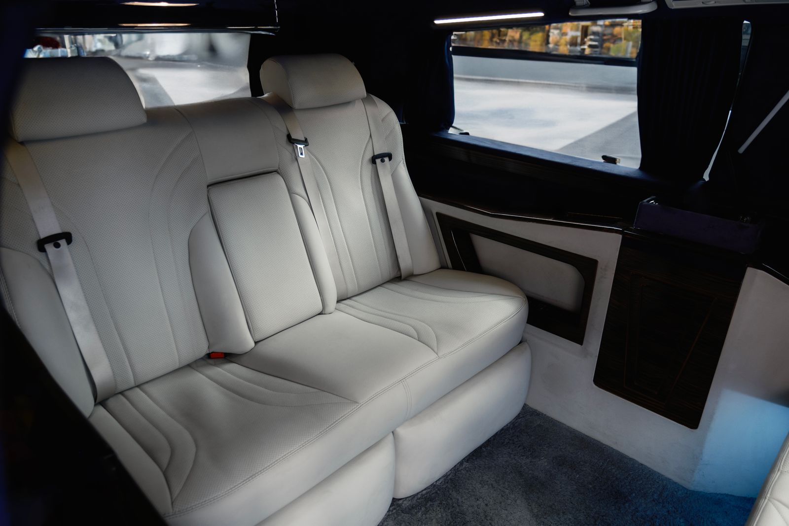 Leather seats inside a black Sprinter van set up for passengers